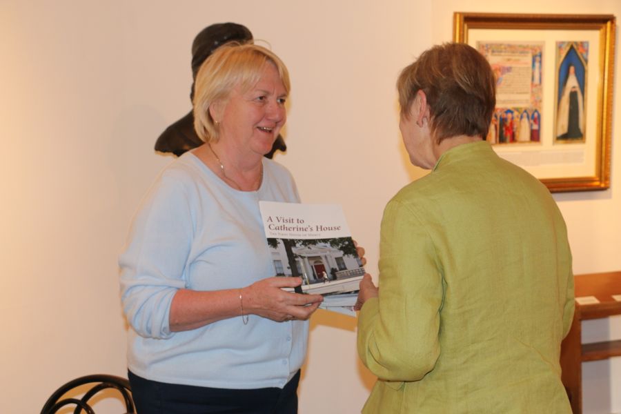 Anne Walsh showing Lorraine Nicholls (volunteer) 'A Visit to catherine's House' guide booklet, 2017